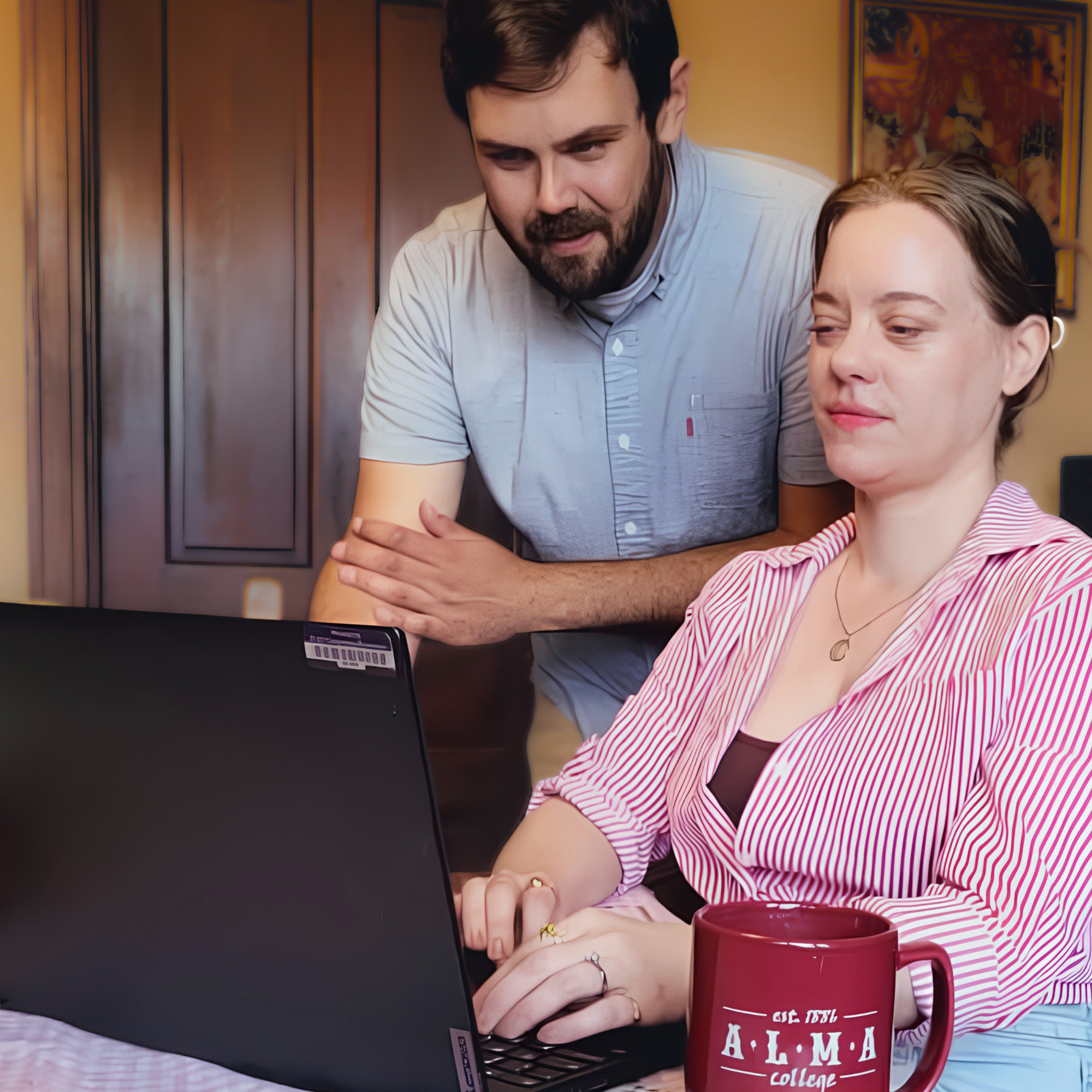 Two people reviewing information on a laptop together.